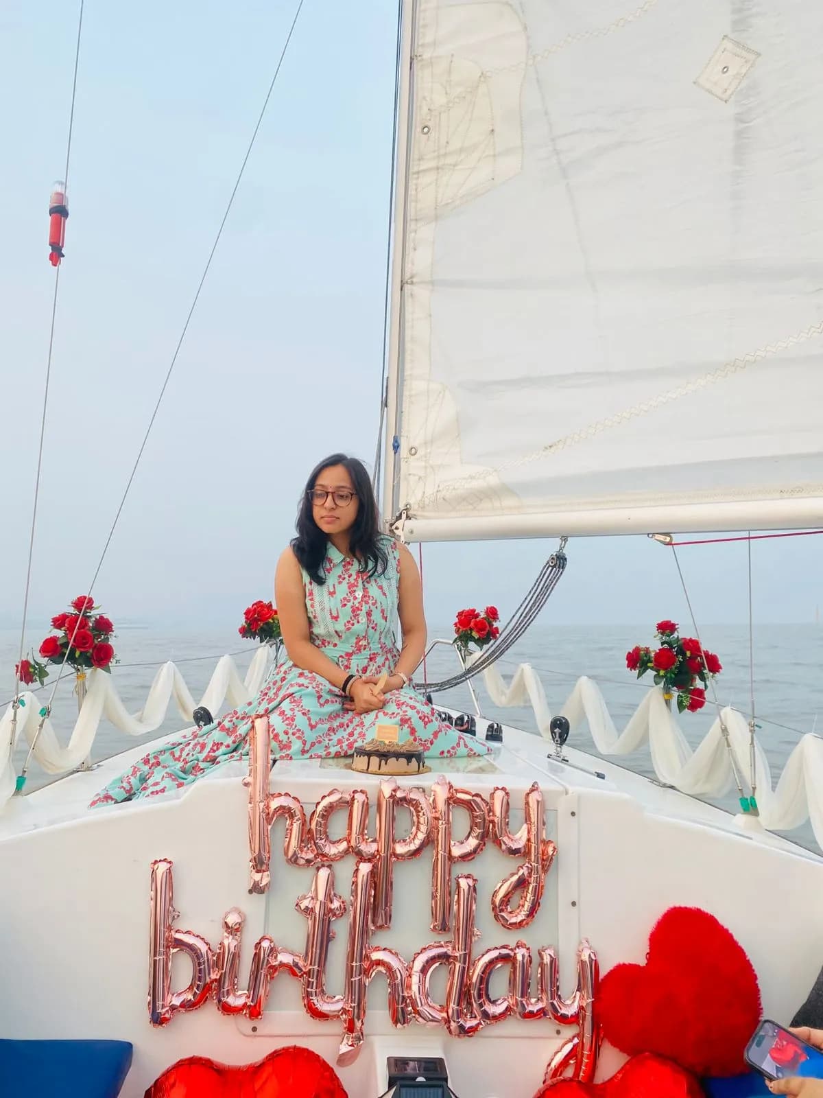 A guest seated at the bow with a birthday cake and rose garlands