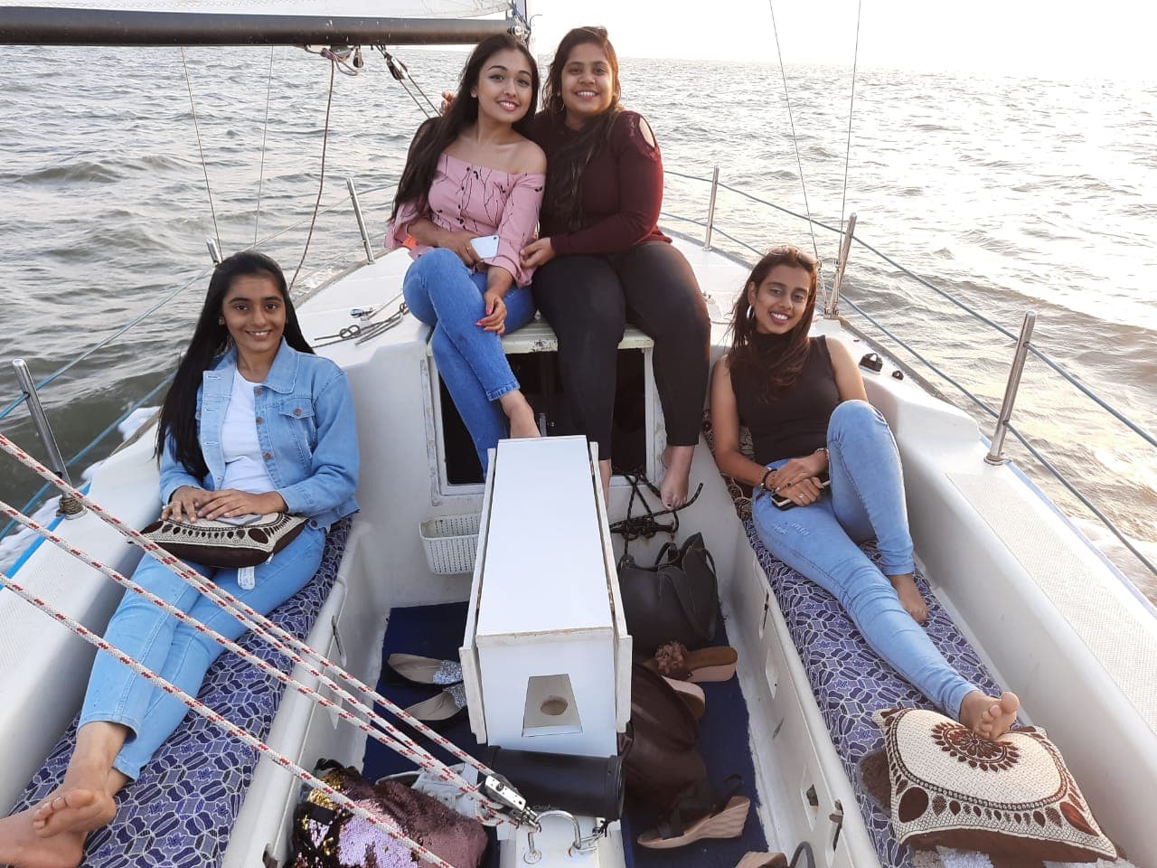 A group of friends relaxing on the bow during a sail