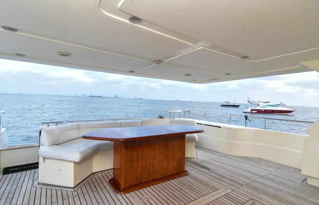 Alfresco dining on the aft deck under the canopy, with other yachts moored nearby