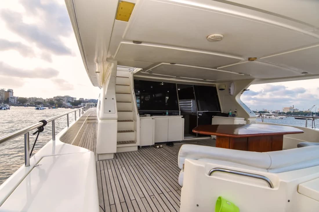The aft deck seating and staircase to the flybridge, with an alfresco dining table