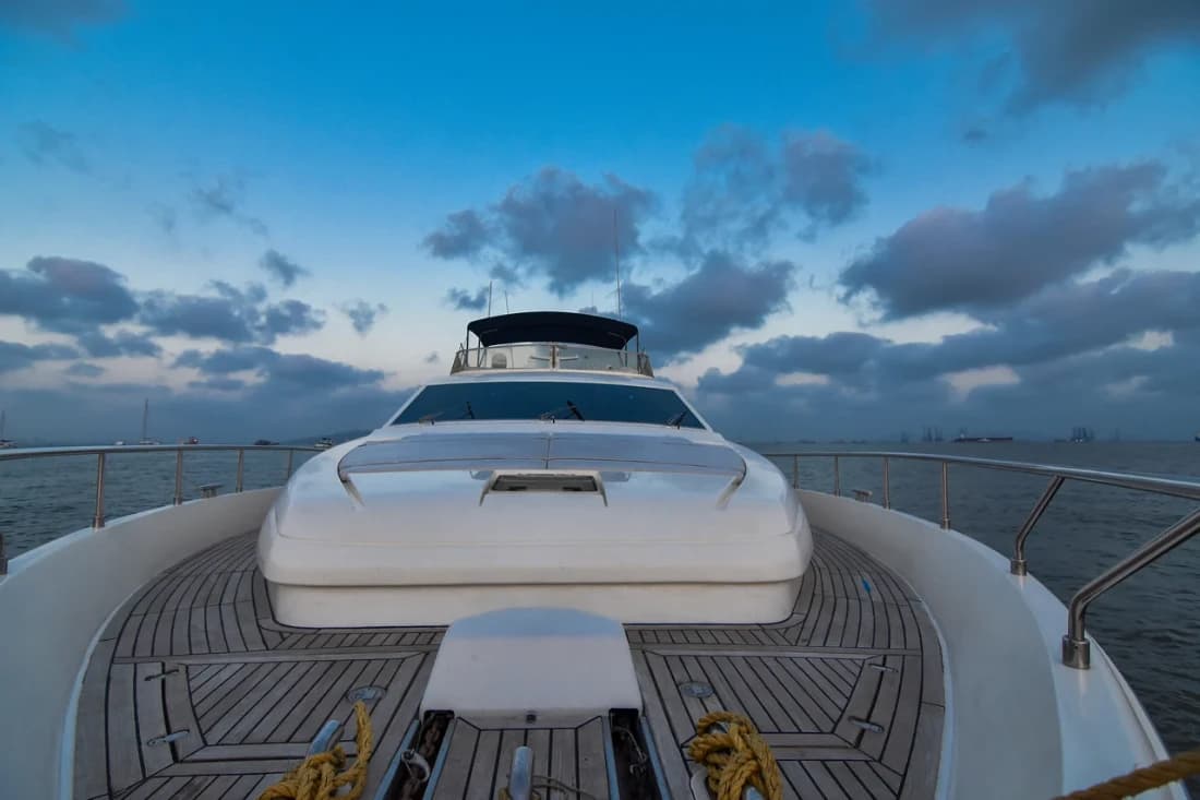 Allegra's foredeck at dusk with the flybridge structure and mooring lines