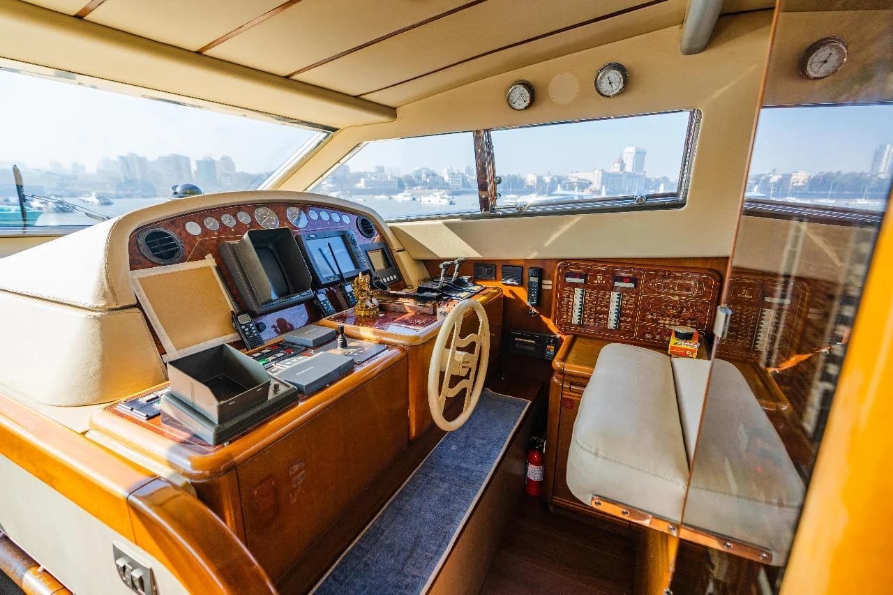 The lower helm's wood dashboard and instruments, with the city skyline visible through the windscreen