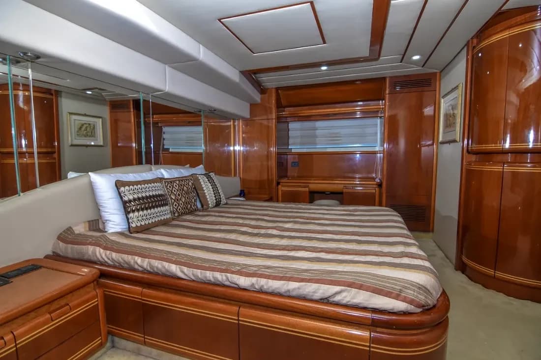 A wood-panelled double cabin with a made-up bed and built-in wardrobes
