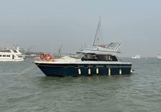 Blue Whale's dark blue hull and flybridge at anchor
