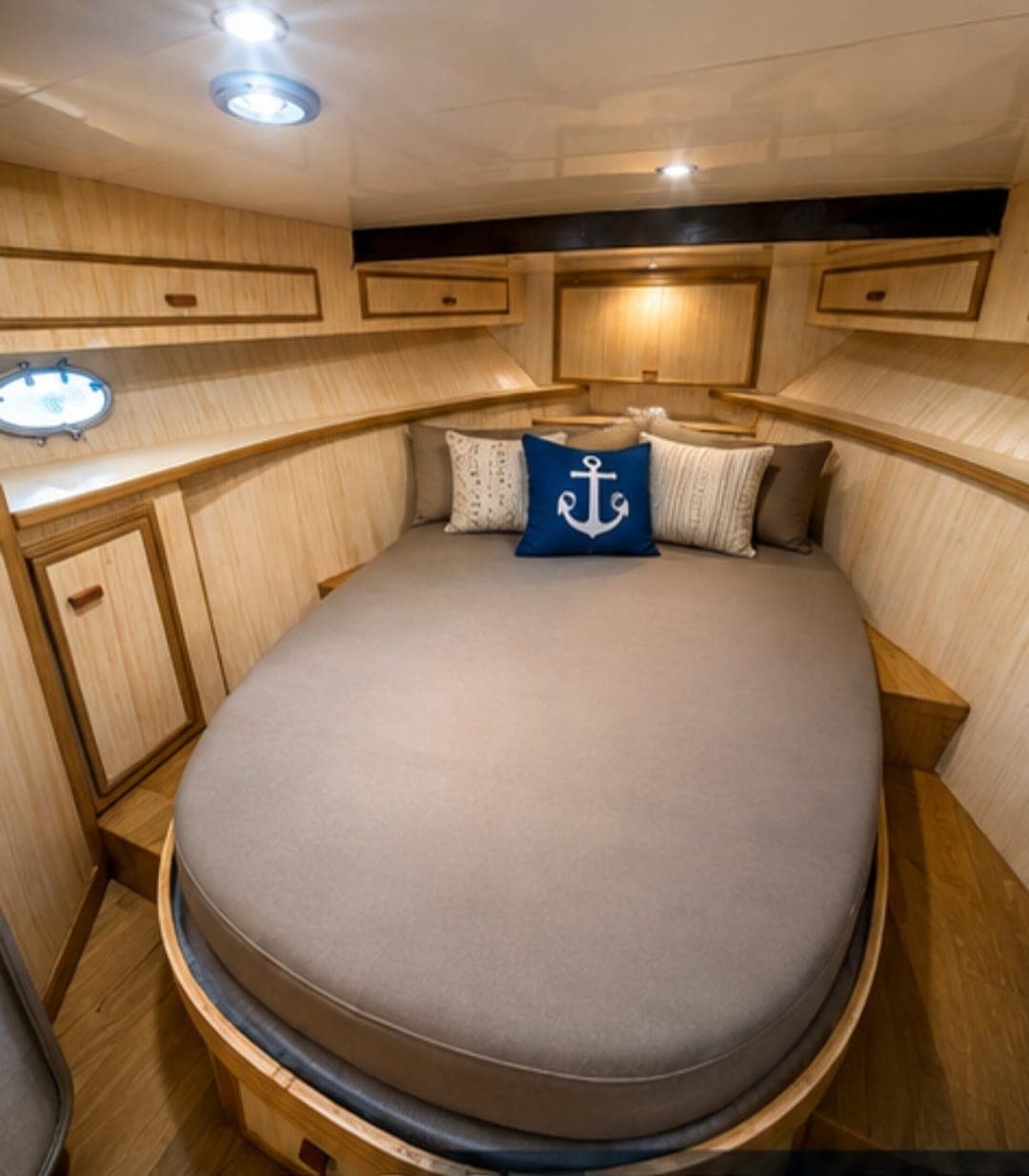 The below-deck cabin with an oval berth and nautical cushions