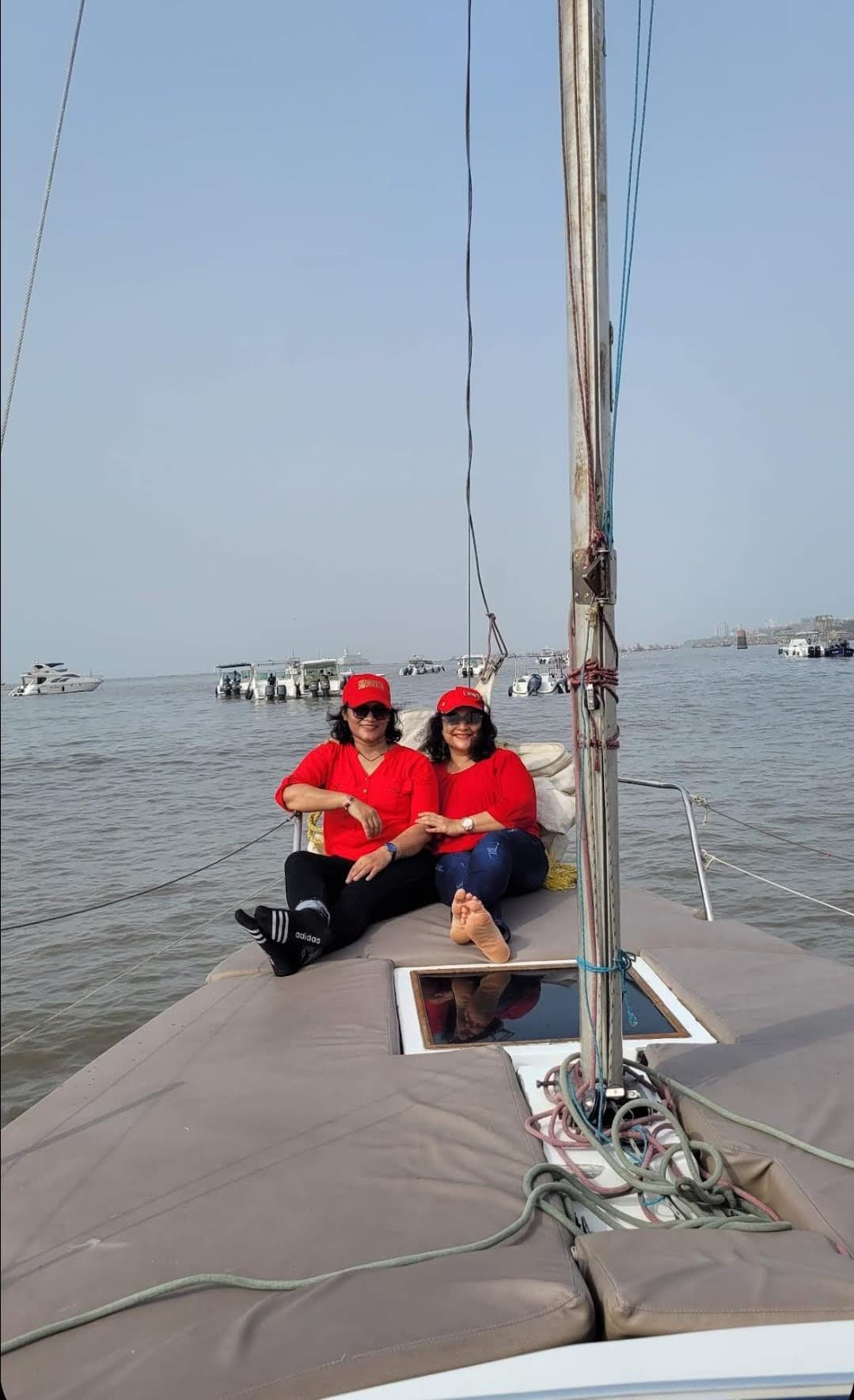 Two guests seated at the bow with other boats moored in the background