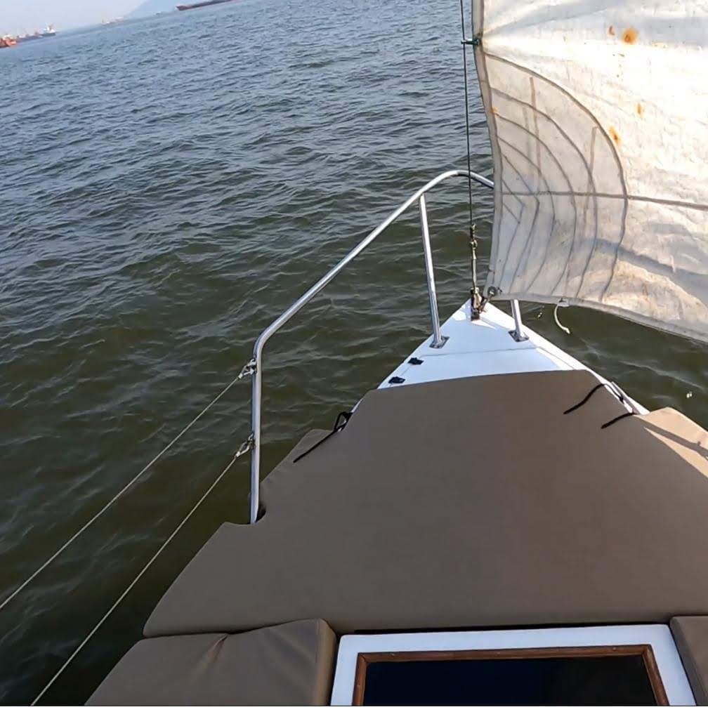 Feeling Nauti's bow under sail with the Mumbai coastline behind