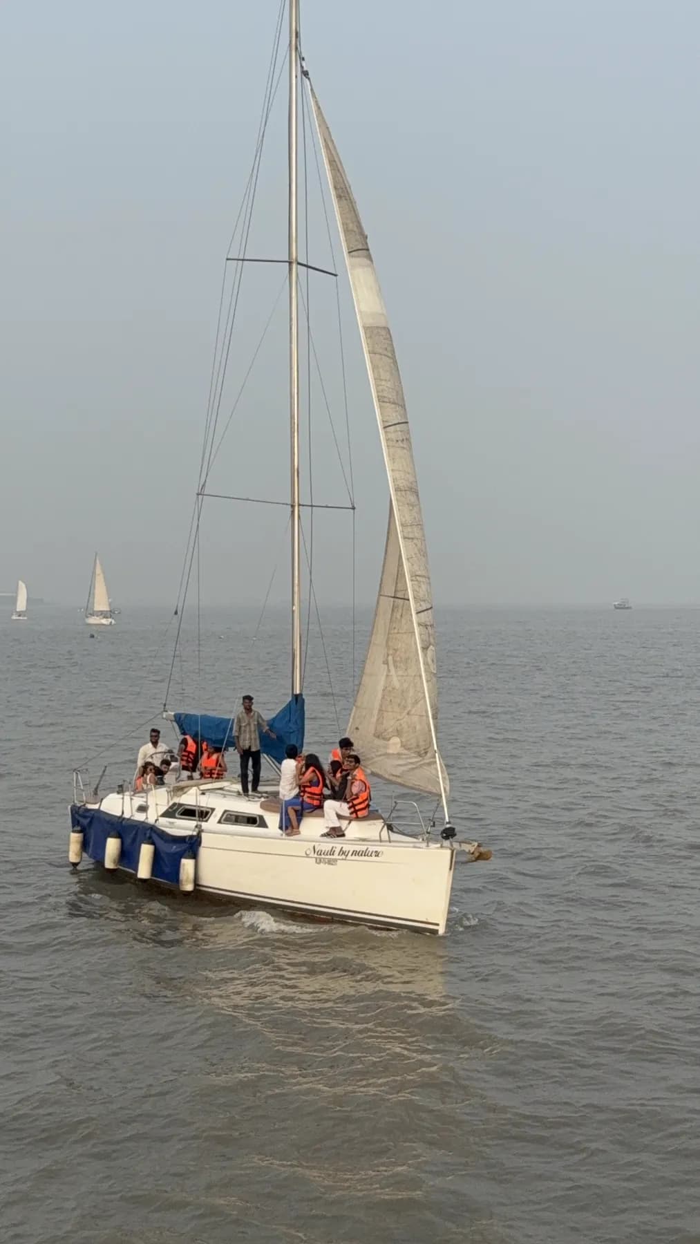 Nauti by Nature under full sail with guests in life jackets aboard