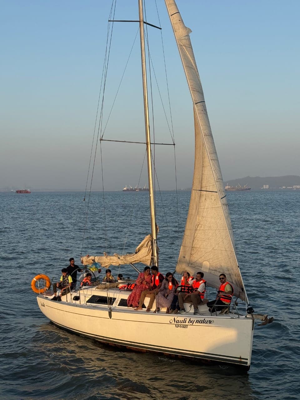Nauti by Nature under sail with her name visible on the stern