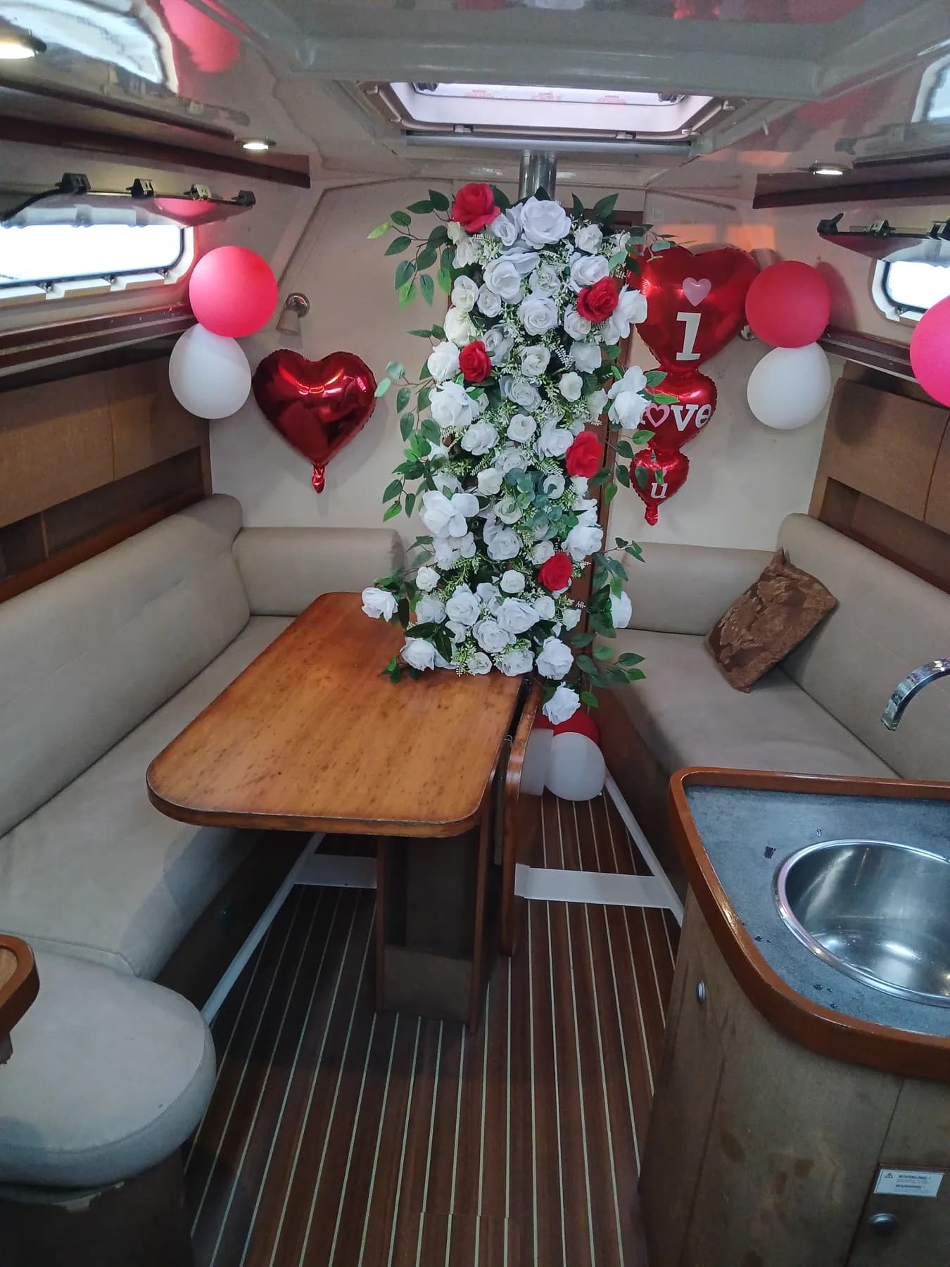 A white and red rose garland proposal set-up in the saloon with I Love You balloons