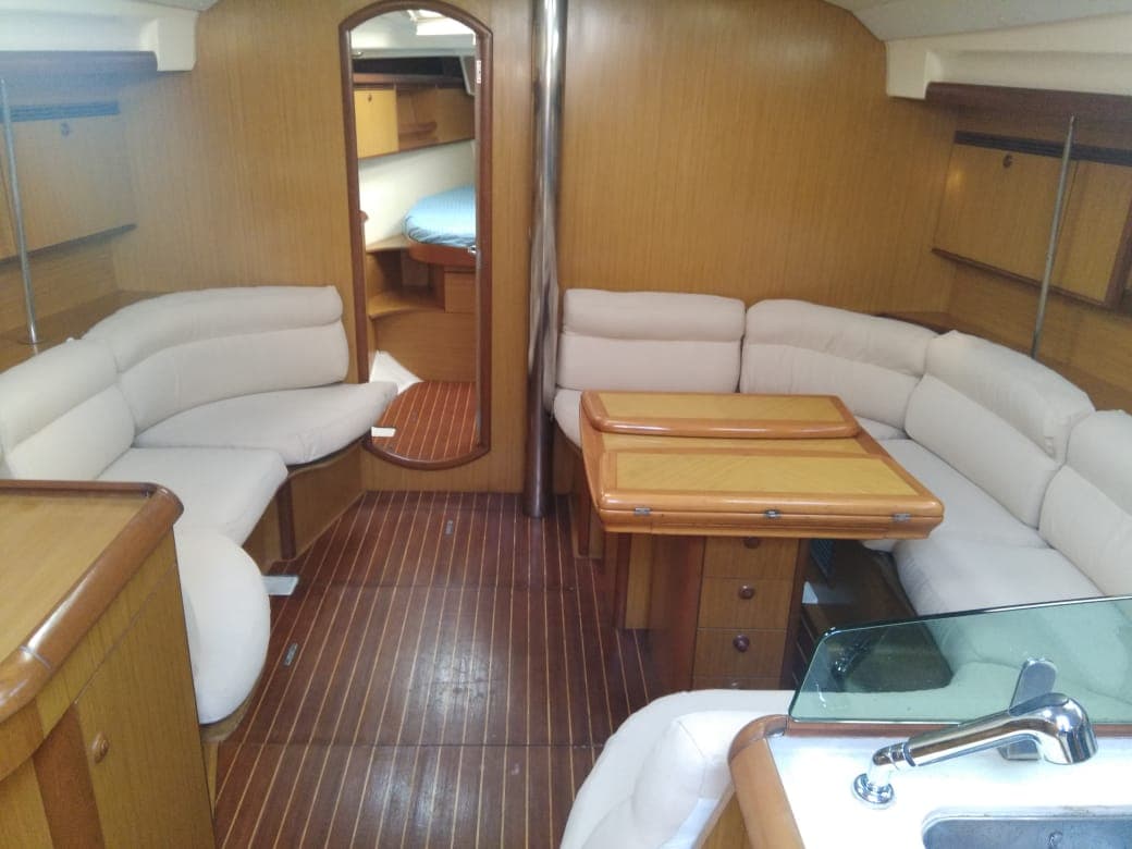 The teak-finished saloon with wraparound seating and a view through to the aft cabin