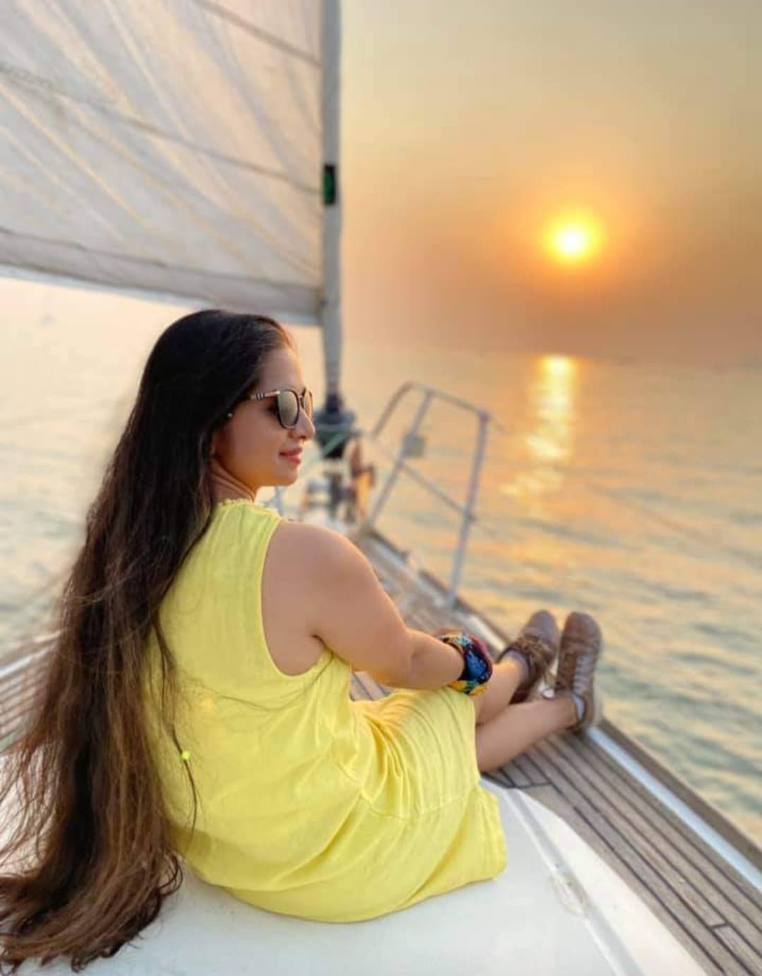 A guest seated at the bow watching the sunset under sail
