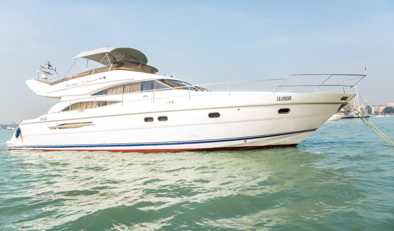 Princess 61 luxury motor yacht at anchor off Mumbai, side profile with the city behind