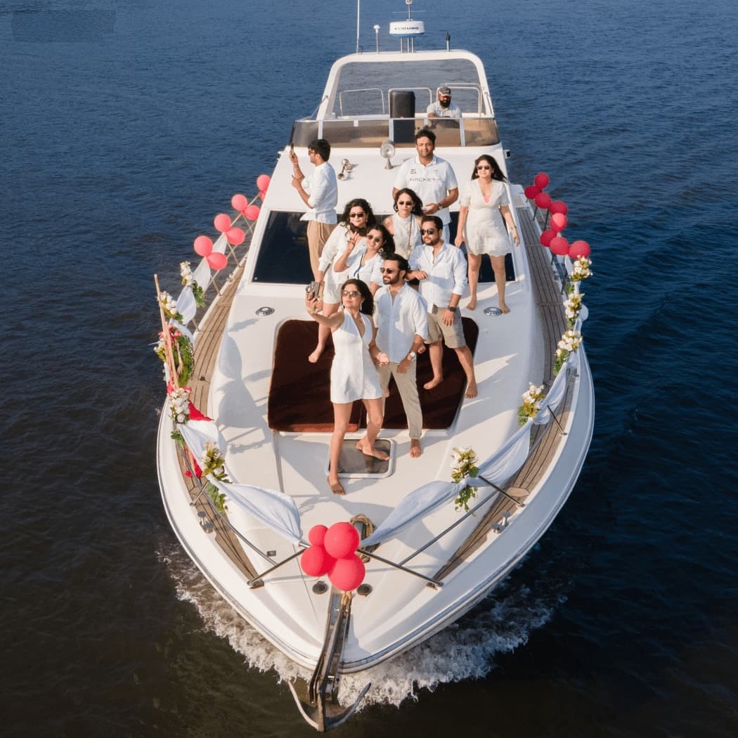 An aerial view of a group celebration on the bow, decorated with balloons and flowers