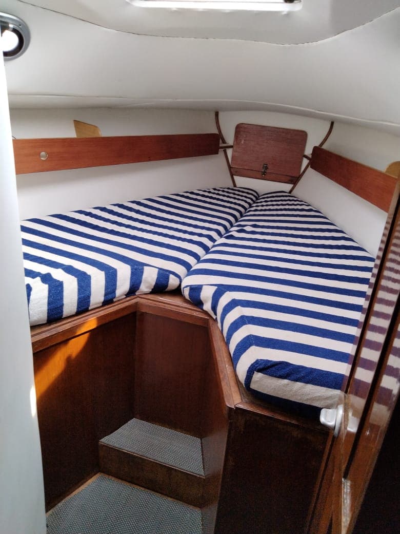 The forward V-berth cabin with striped cushions