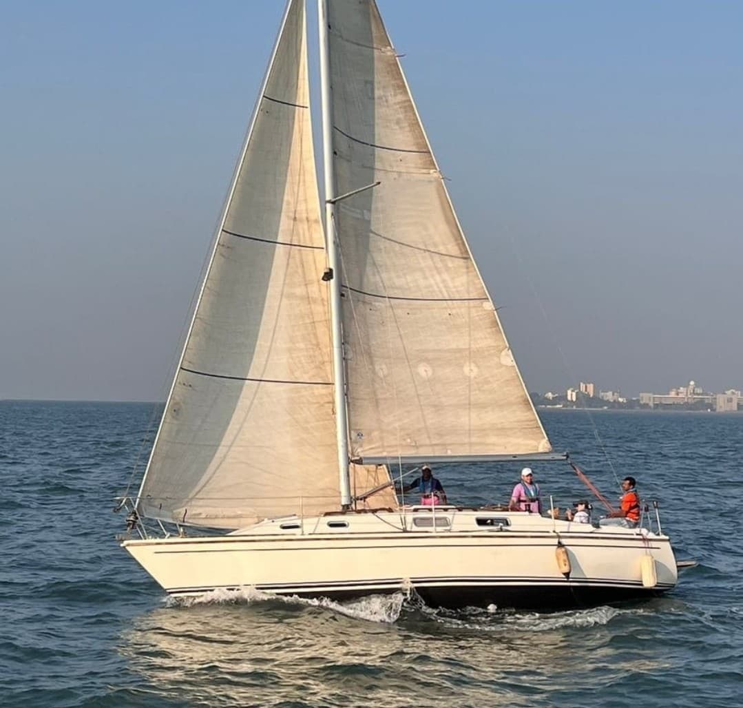 Guests seated in the cockpit under sail with the crew at the helm