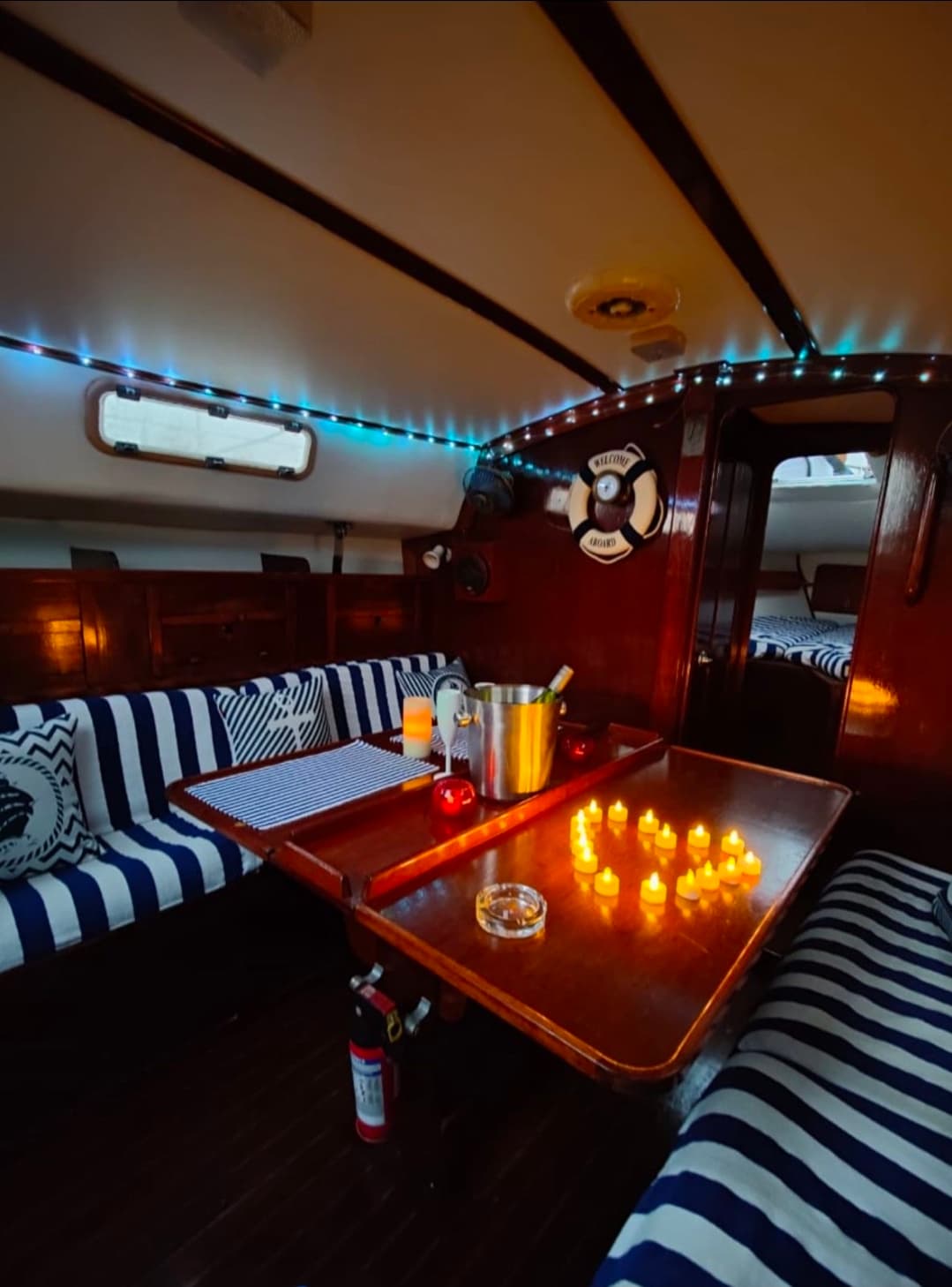 A romantic dinner set-up below deck with fairy lights, champagne and candles