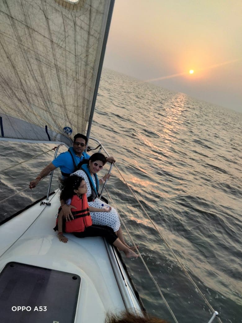A family seated at the bow watching the sunset with a child in a life jacket