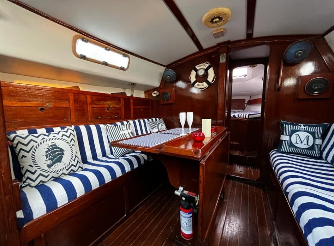 The teak-finished saloon with striped cushions and a fold-down dining table