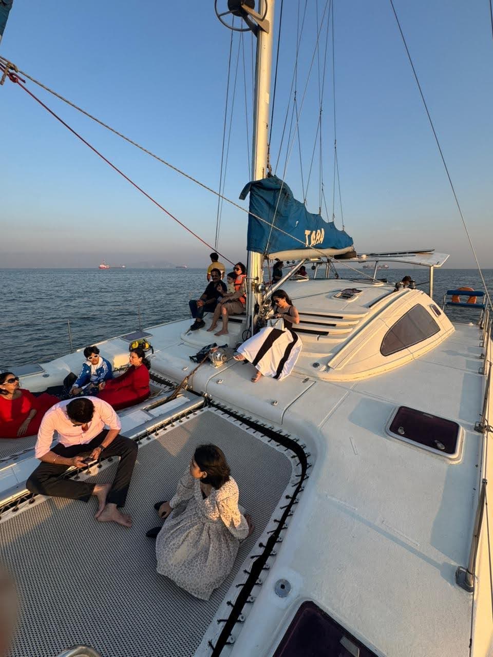 Guests on Tara's aft deck at sunset beside the old coastal battery fort