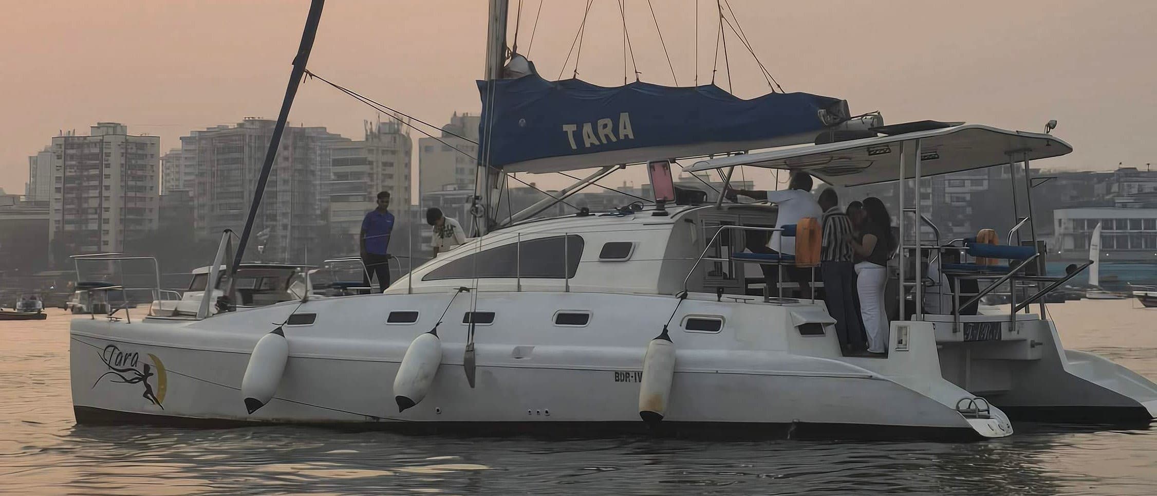 Tara, a sailing catamaran, under way off Mumbai past the Middle Ground coastal battery with the city skyline behind