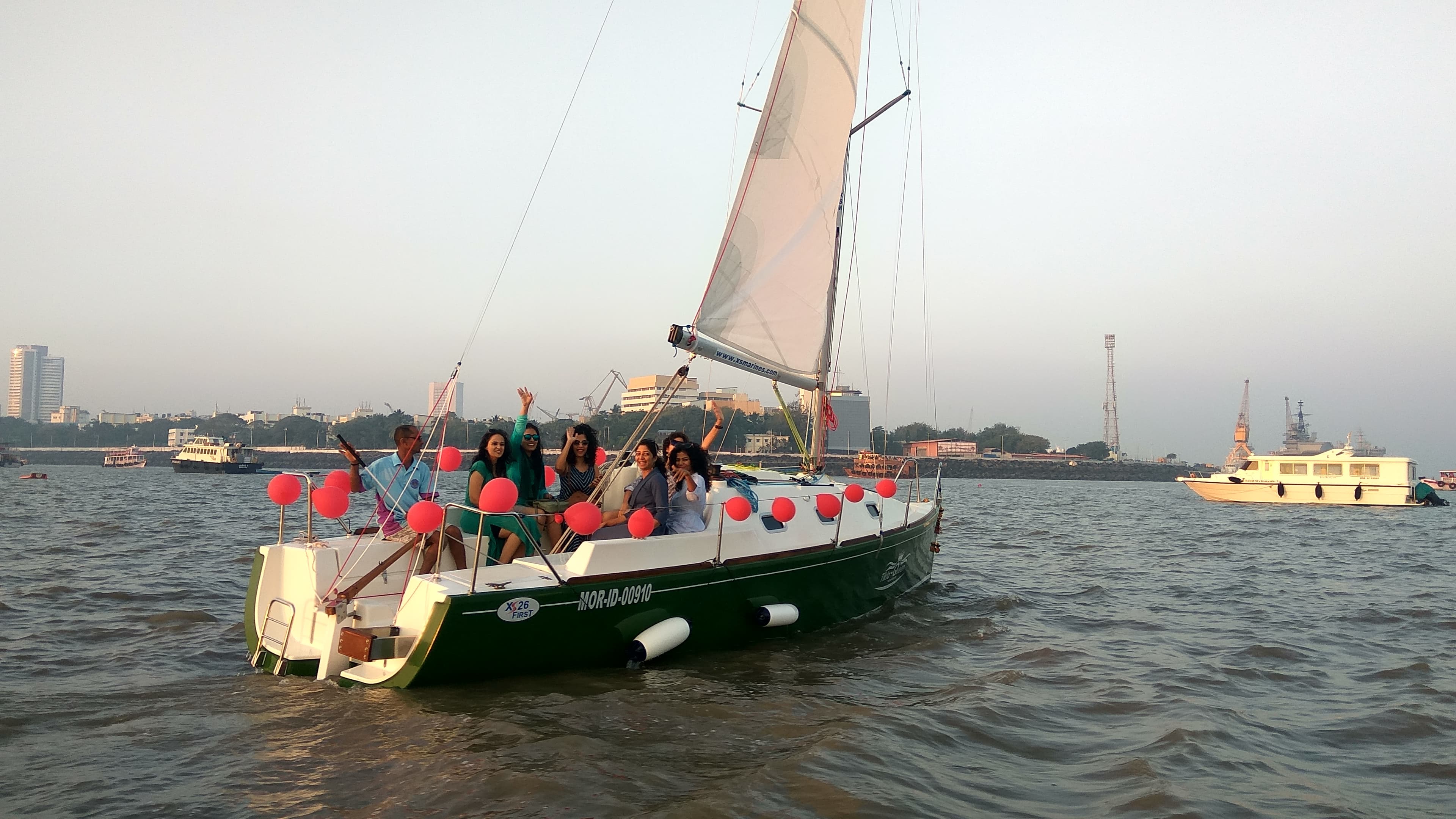 A group celebration aboard Tikla Queen decorated with red balloons, under sail