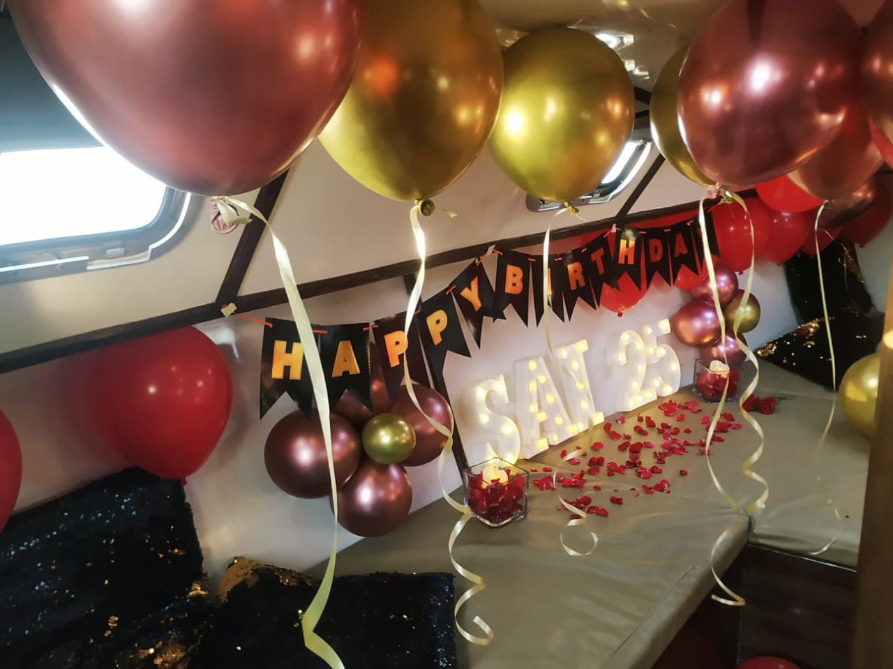 A birthday decoration set-up in the cuddy cabin with balloons and rose petals