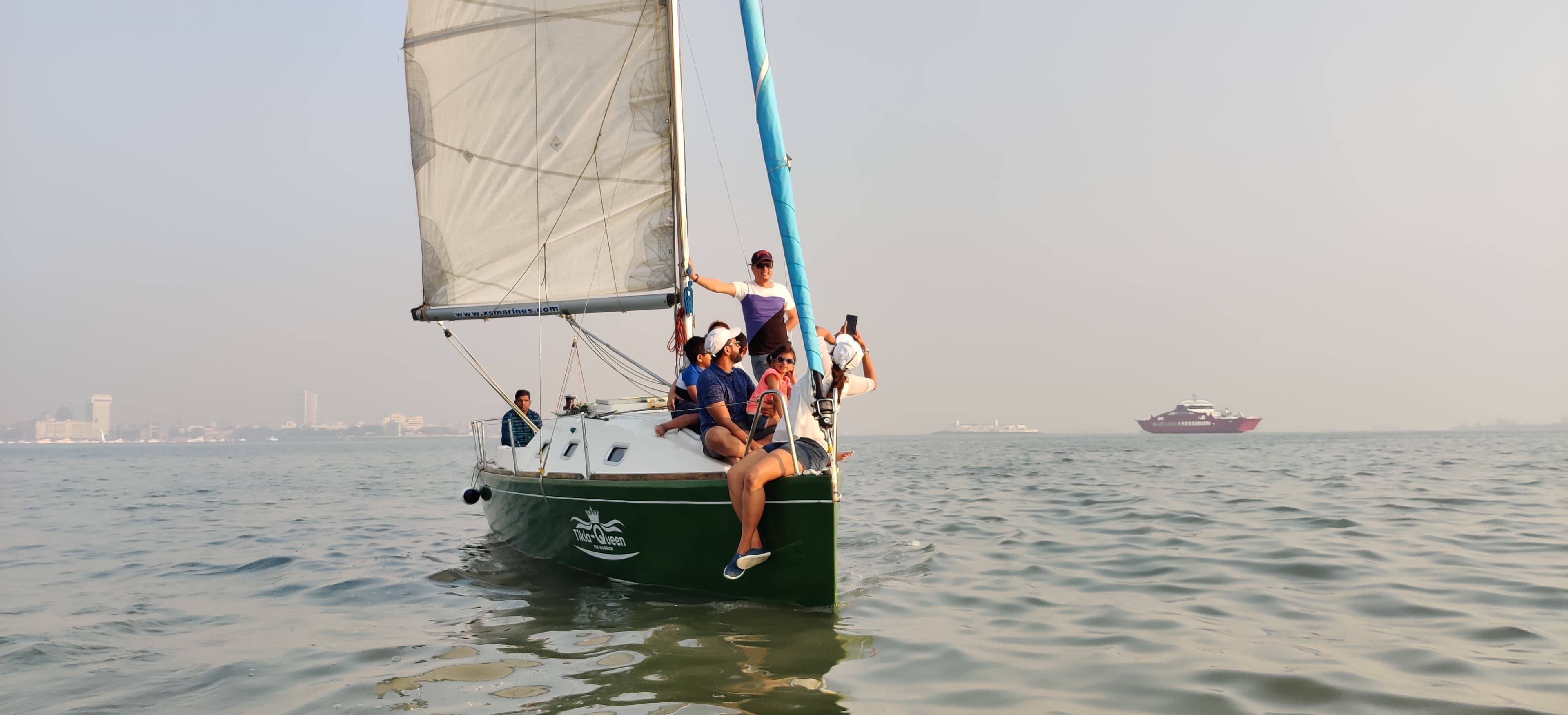 A family with a young child seated at the bow under sail