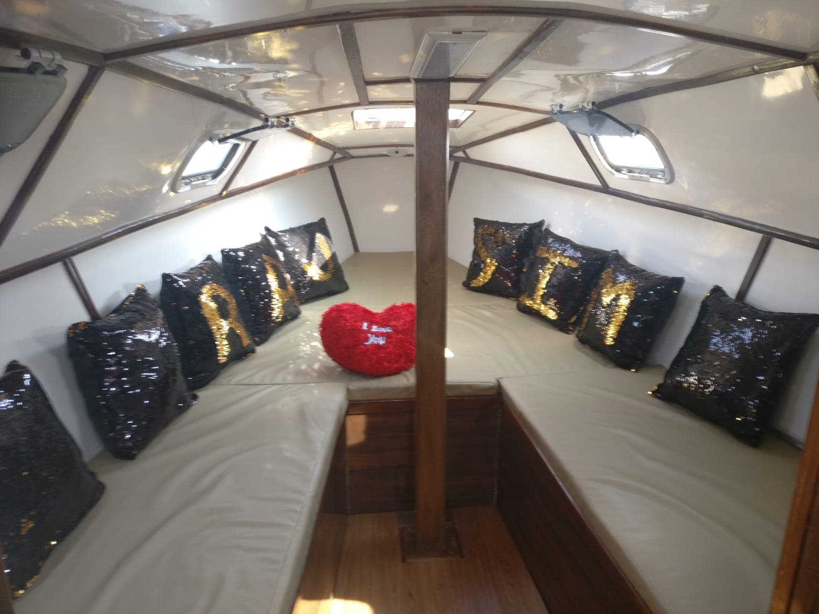 The below-deck cuddy cabin with monogrammed sequin cushions for a celebration