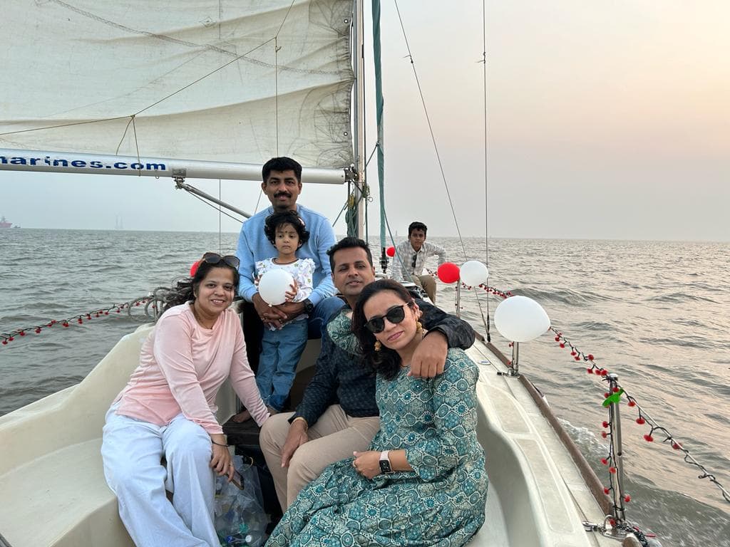 A family group photo on deck decorated with a red and white balloon string