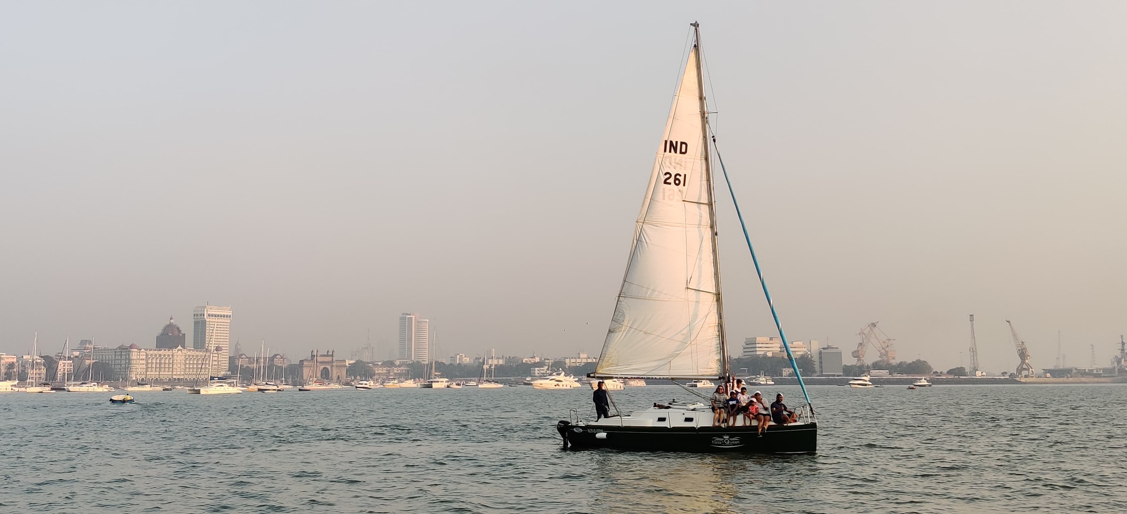 Tikla Queen under sail with the Taj Mahal Palace and Gateway of India in the distance