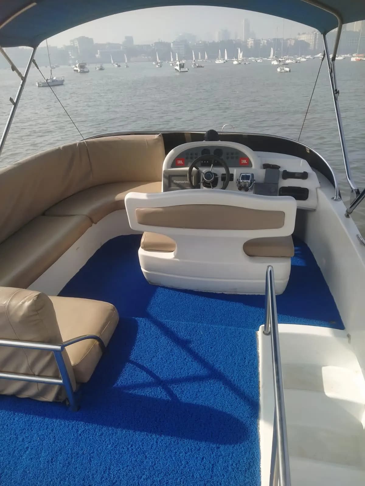 The flybridge upper helm and seating with the Mumbai skyline behind