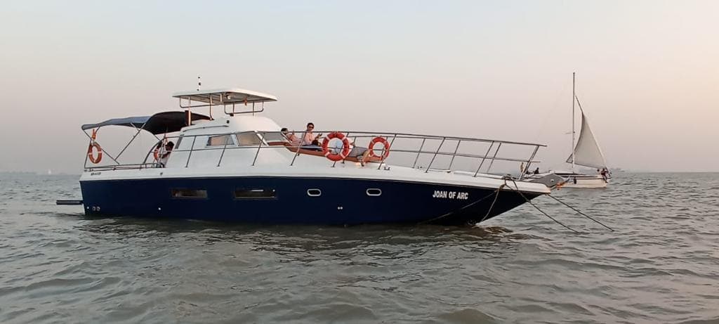 Joan of Arc's side profile with her nameplate, moored on the Mandovi
